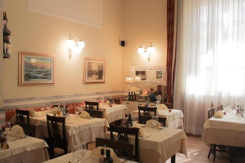 ミラノにあるVilla Lia Depandance Hotel Siciliaのダイニングルーム(テーブル、椅子、白いテーブルクロス付)