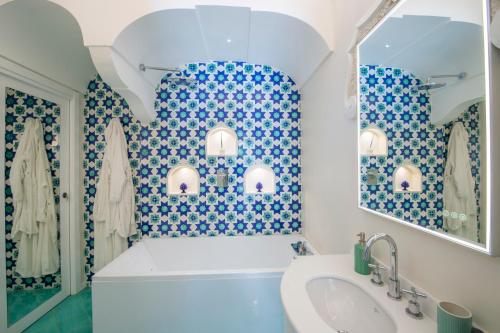 a bathroom with blue and white tiled walls and a sink at Casa Don Ciccio Positano in Positano