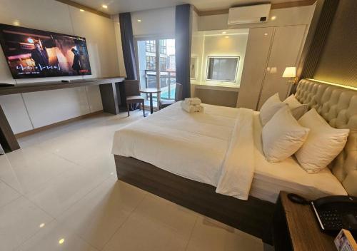 Cette chambre comprend un grand lit et une télévision. dans l'établissement THE TIMES HOTEL, à Ángeles