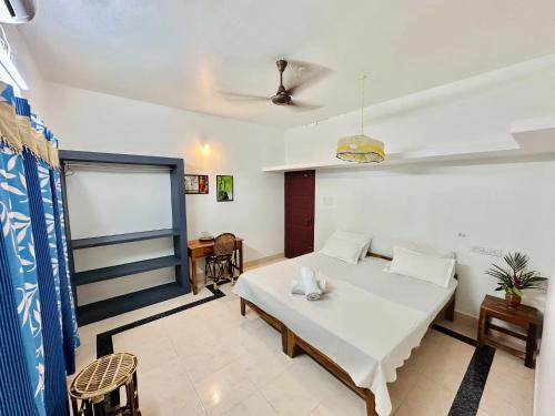 a bedroom with a bed and a table and chairs at Varkala Villa in Varkala