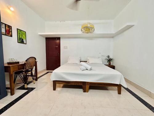 a bedroom with a bed and a desk in it at Varkala Villa in Varkala