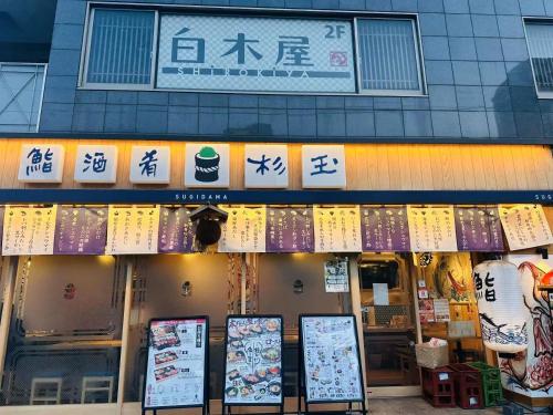 a restaurant with signs on the front of a building at 【都電屋203】标准间/都电荒川线/近三ノ輪/一线直达秋叶原/上野/浅草 in Tokyo