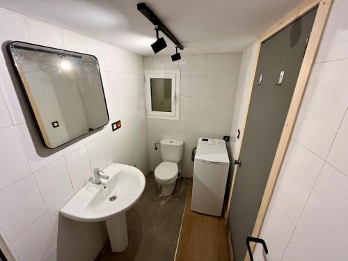 a bathroom with a sink and a toilet and a mirror at Lotila Flats Villaviciosa in Villaviciosa