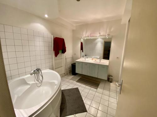 a white bathroom with a tub and a sink at Duplex à 120 m du lac d'Annecy in Duingt