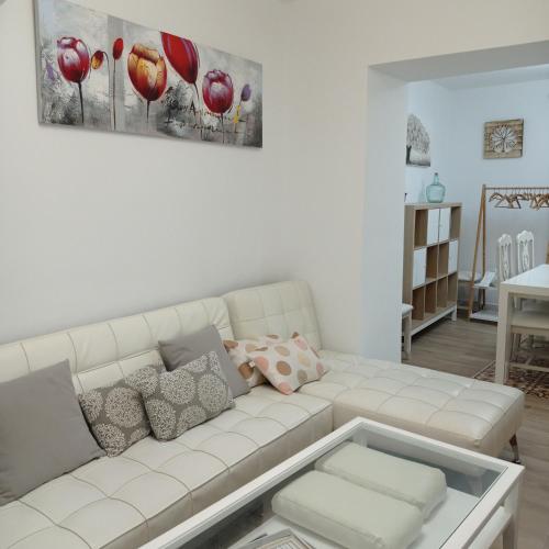 una sala de estar blanca con un sofá blanco con almohadas en Casa Chacha Tere, en Montoro