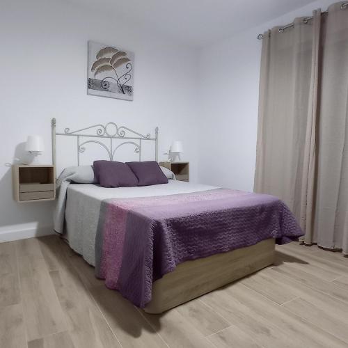 1 dormitorio con 1 cama con manta morada en Casa Chacha Tere, en Montoro