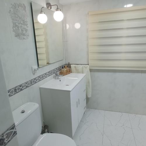 a bathroom with a toilet and a sink and a mirror at Casa Chacha Tere in Montoro