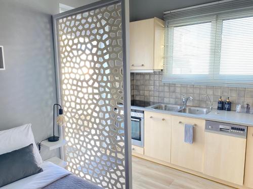 uma cozinha com uma porta de vidro para uma cozinha com um lavatório em TINY LITTLE STUDIO em Atenas