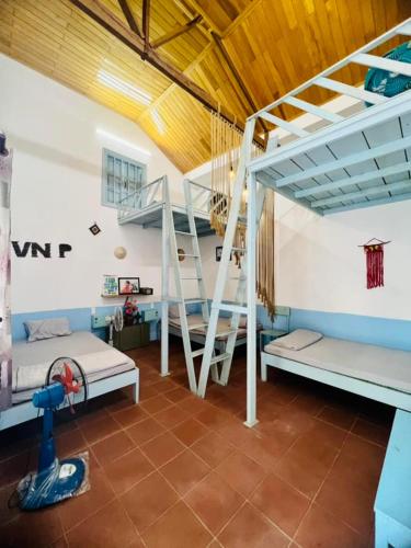 a room with three bunk beds and a staircase at Vietnam Phuot Real Home in Kon Tum