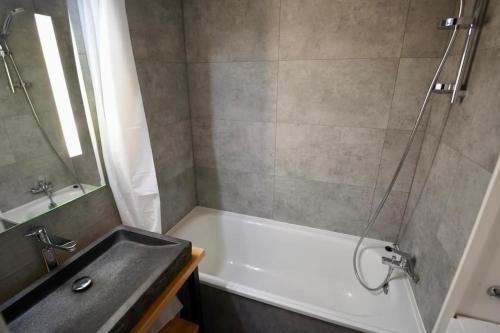 a bathroom with a tub and a sink and a shower at Val Thorens Studio 2 personnes et balcon Plein Sud in Val Thorens