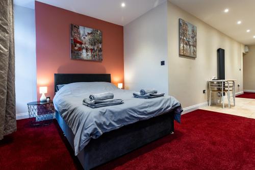 a bedroom with a bed and a red carpet at St Benedicts Apartments in Norwich