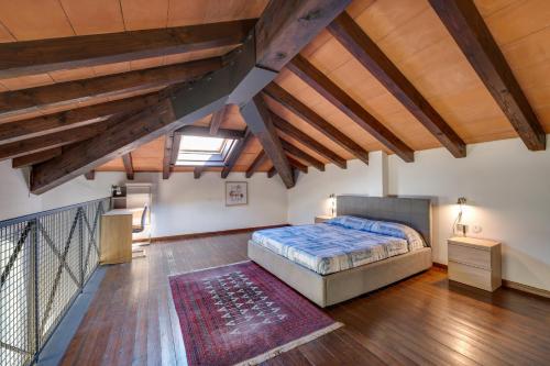 - une chambre mansardée avec un lit et des plafonds en bois dans l'établissement Bigattera lofts - Affitti Brevi Italia, à Varèse