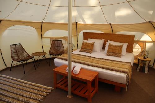 a bedroom in a tent with a bed and a table at Cabañas Tequendama - Parque Tayrona in El Zaino