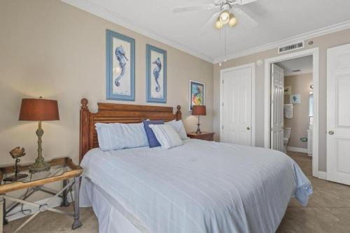 a bedroom with a large white bed with blue pillows at Island Royale P102 in Gulf Shores