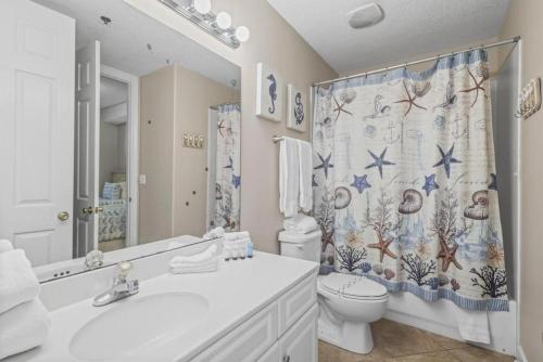 a bathroom with a toilet and a shower curtain at Island Royale P102 in Gulf Shores