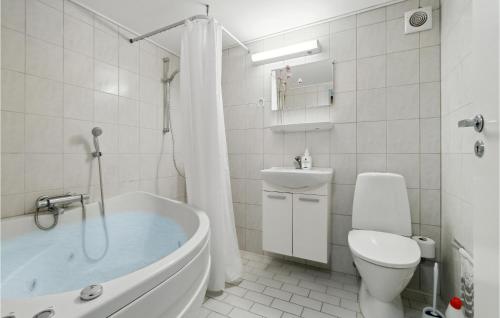 a bathroom with a tub and a toilet and a sink at Amazing Apartment In Allinge With Kitchen in Sandvig