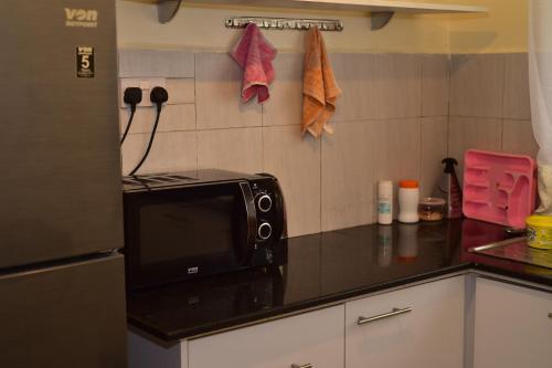 una cucina con forno a microonde su un bancone di Dennis Prince pm comfy home a Nairobi