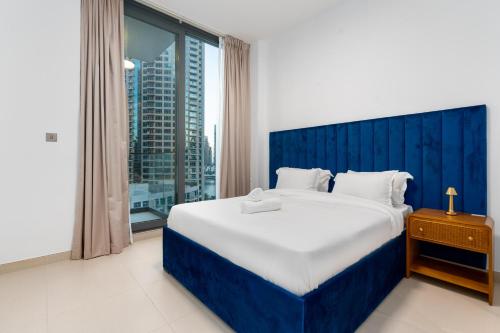 a bedroom with a large bed and a large window at ArbabHomes Lavish 2BR Dubai Marina View-LIV Residences in Dubai