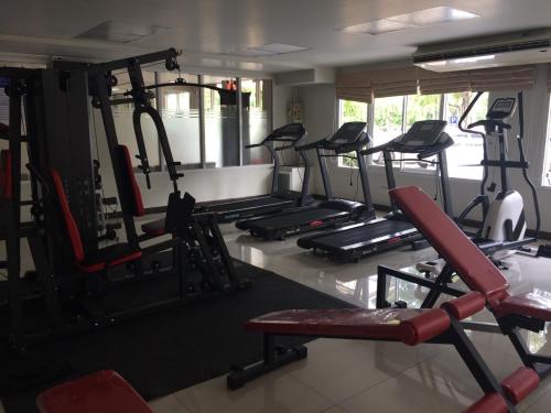 un gimnasio con varias cintas de correr y bicicletas estáticas en โรงแรม ศิราภา เรสซิเด้นท์ จำกัด en Chachoengsao