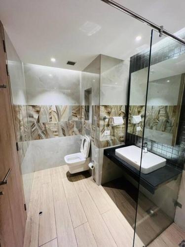 a bathroom with a toilet and a glass shower at Luxury Studios Key 4 in Gurgaon