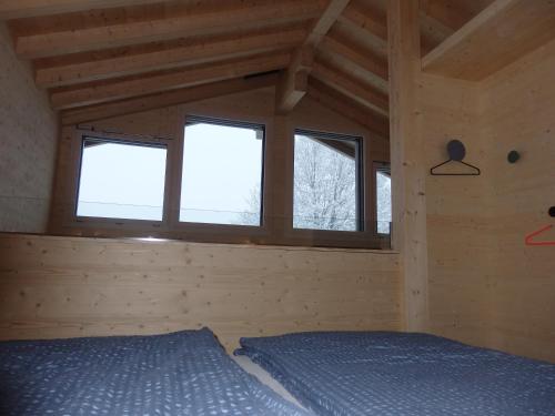 ein Schlafzimmer mit einem Bett in einer Holzhütte in der Unterkunft Bätzenboden Stöckli 1375A in Wengen