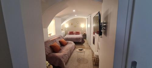 ein Wohnzimmer mit einem Sofa und einem Bett in der Unterkunft Au coeur du village de Vals in Vals-les-Bains