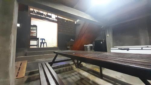 a large wooden bench in a room with a window at Gonias Hostel in Gunungsitoli