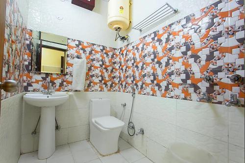 a bathroom with a toilet and a sink at Trimrooms Trinity Katra in Katra