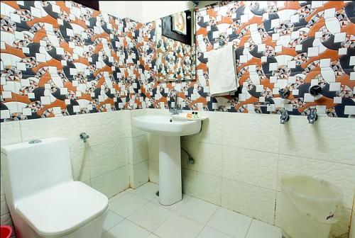 a bathroom with a toilet and a sink at Trimrooms Trinity Katra in Katra