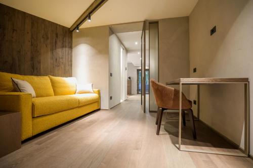a living room with a yellow couch and a table at Collina Luxury Relais in Clusone