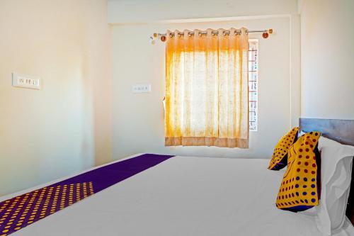 um quarto com uma cama e uma janela em OYO Hotel Om Classic em Sarjāpur