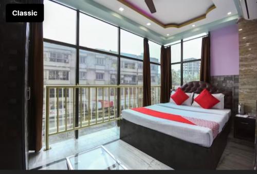 a bedroom with a bed and a balcony with windows at Hotel Nest Park Street in Kolkata