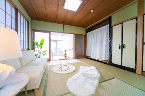 uma sala de estar com um sofá branco e uma mesa em 菰野ガーデンリゾート 