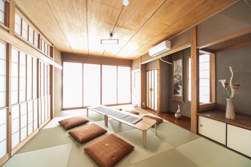 uma sala de estar com uma mesa e algumas janelas em 菰野ガーデンリゾート 
