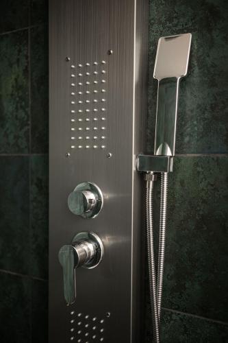 a shower in a bathroom with a metal door at Hotel Dymník in Rumburk