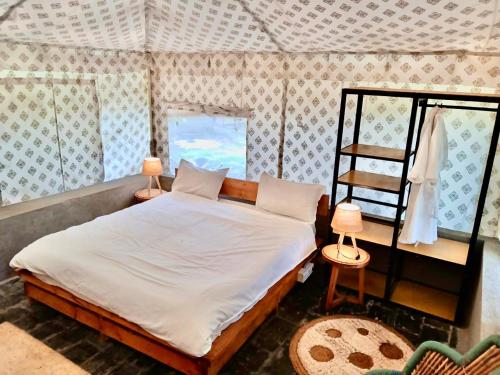 a bedroom with a large bed in a room at H2H Bir l Nature Camps in Bīr