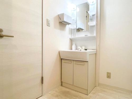 a small bathroom with a sink and a mirror at Dolce Shibuya in Tokyo