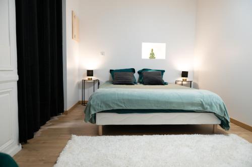 una camera da letto con un grande letto con cuscini blu di Chez Rose - Plein Centre Historique a Langres
