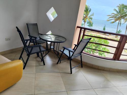 a table and chairs in a room with a view of the ocean at Lamera in Mombasa