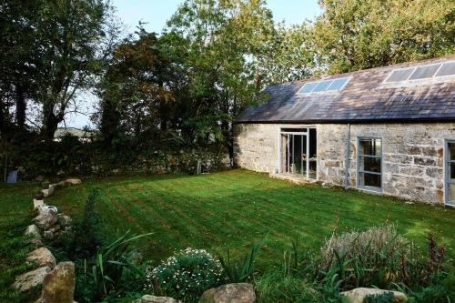 uma velha casa de pedra com um quintal em frente em Crab Lane Studios em Carlow