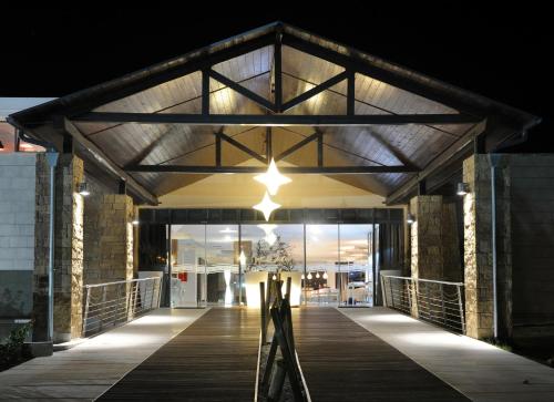 un paseo marítimo que conduce a un edificio por la noche en Istion Club & Spa en Nea Potidaea