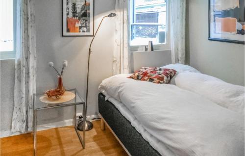 a bedroom with a bed and a lamp and a table at Lovely Apartment In Kattem With Sauna in Lund