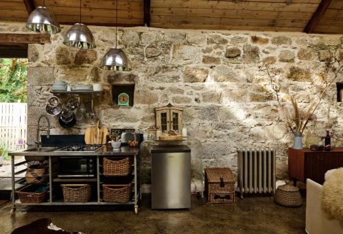 a kitchen with a stove and a stone wall at Crab Lane Studios in Carlow