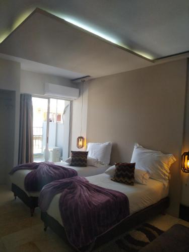 two beds in a hotel room with a large window at CENTRAL VIEW ΜΙΔΕΙΑ in Levádeia