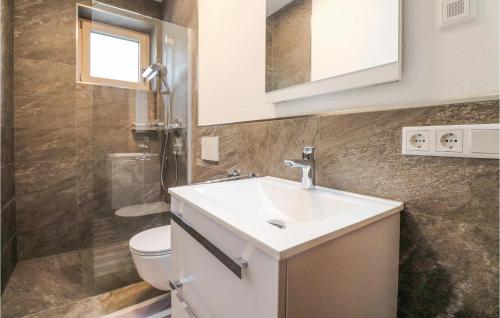 y baño con lavabo, aseo y espejo. en Stunning Apartment In Fieberbrunn With Wi-fi, en Fieberbrunn
