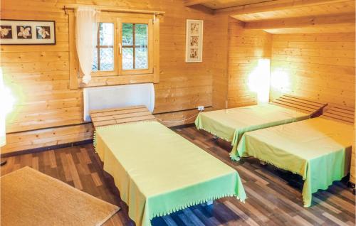 2 Betten in einem Zimmer mit Holzwänden in der Unterkunft Awesome Home In Pillberg With Sauna in Hochpillberg