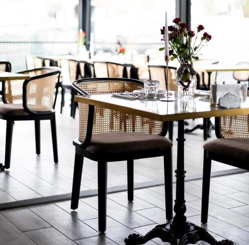 a table with chairs and a vase of flowers on it at R.HOTEL in Chernivtsi