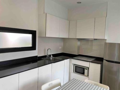 a kitchen with white cabinets and a sink at Luxury condo in phuket shopping center in Phuket