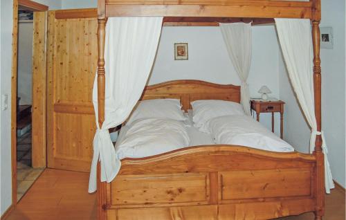 1 dormitorio con cama de madera con dosel y almohadas blancas en Hanselerhof, en Rinn