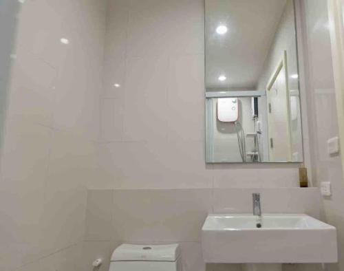 uma casa de banho branca com um lavatório e um WC em Luxury condo in phuket shopping center em Phuket
